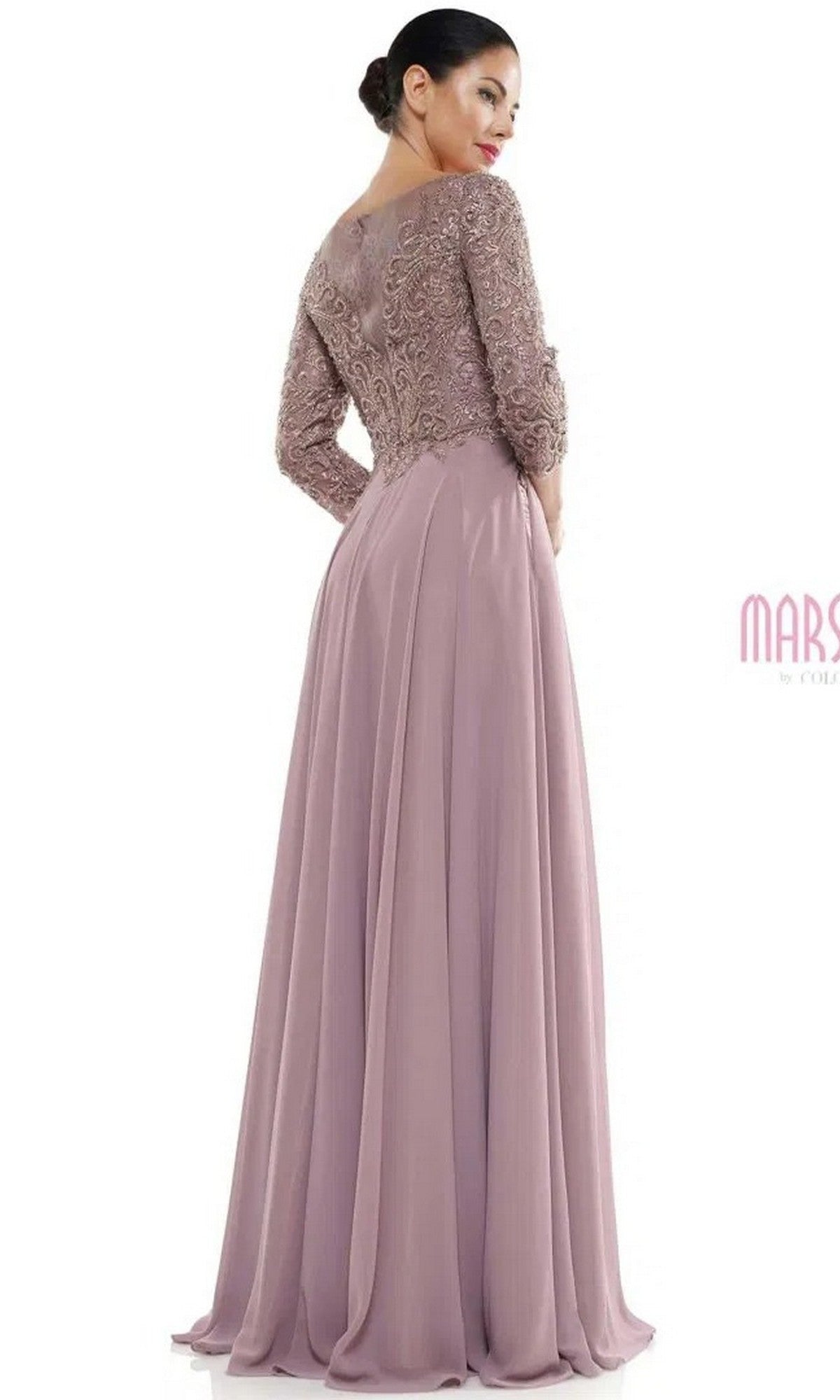 A woman stands with her back turned, hair in a low bun, wearing the Marsoni MV1052—a long mauve formal dress featuring modest lace and beaded detailing on the fitted sleeves.